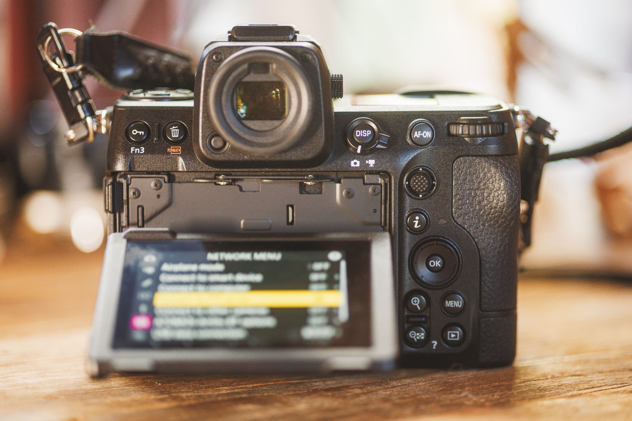 A digital camera with an open LCD screen, akin to a vehicle draft displaying intricate plans, sits elegantly on a wooden surface.