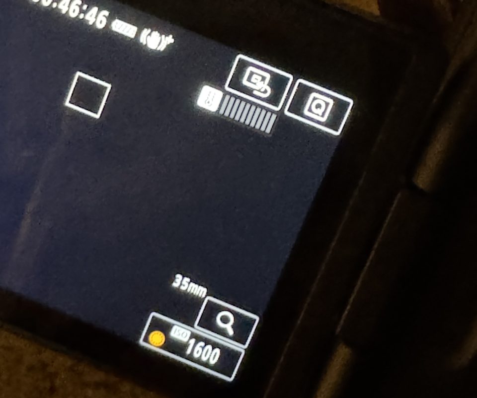 Close-up of a digital camera screen displaying settings, including 35mm lens, ISO 1600, battery level, and focus frame—perfect for our Canon R1 review.