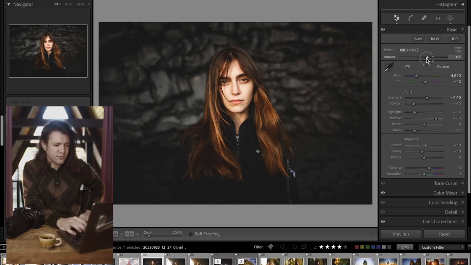 A person with long brown hair stands against a dark, rocky background, looking at the camera, showcasing the real-world use of the Nikon Z8.